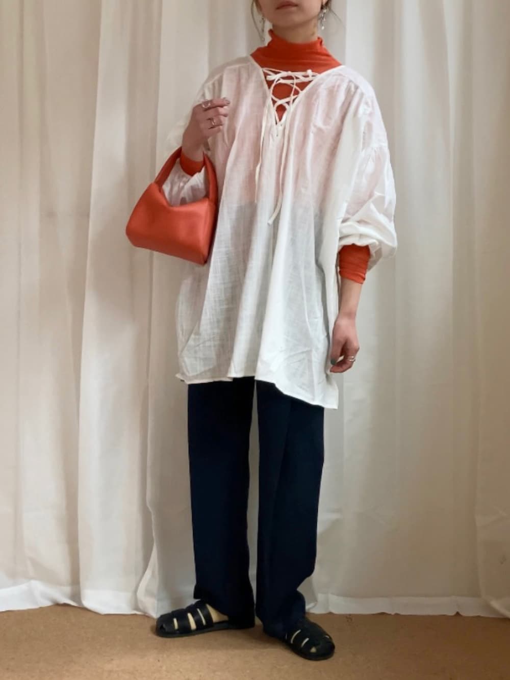 ホワイト系のシャツ/ブラウス、オレンジ系のTシャツ/カットソー、ブルー系のパンツを着用したレディースの春コーディネートの1枚目の写真