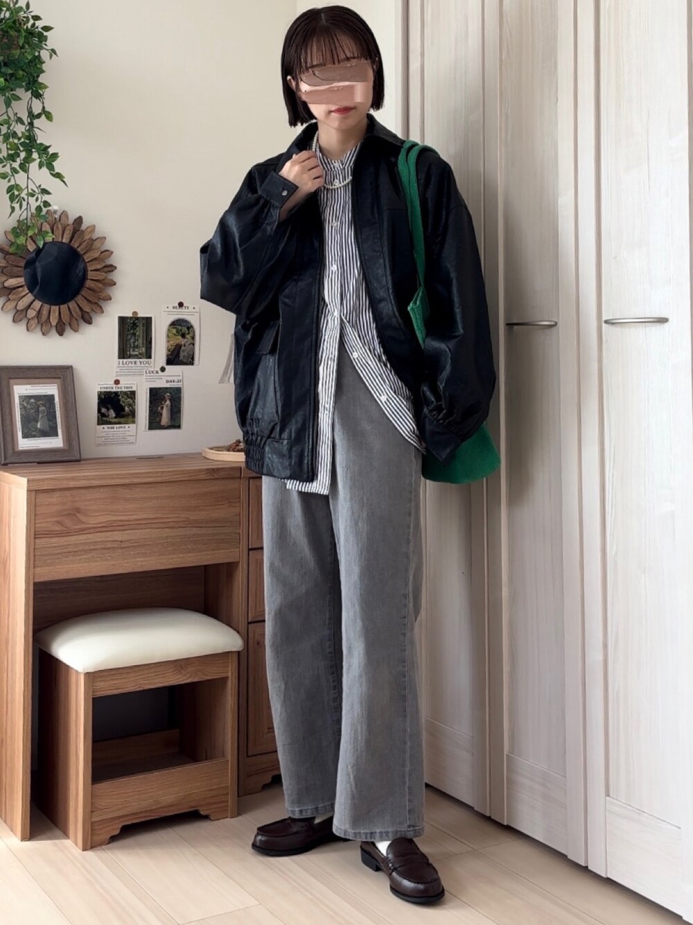 ブラック系のブルゾン、ブルー系のシャツ/ブラウス、グレー系のデニムパンツを着用したレディースの秋コーディネートの1枚目の写真
