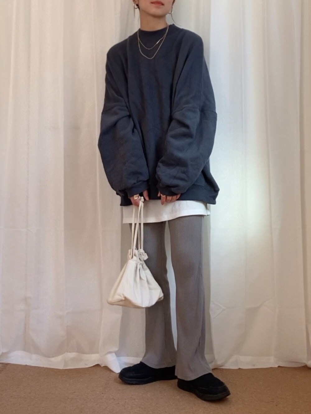 グレー系のスウェット、ホワイト系のショルダーバッグ、ブラック系のシューズを着用したレディースの秋コーディネートの1枚目の写真