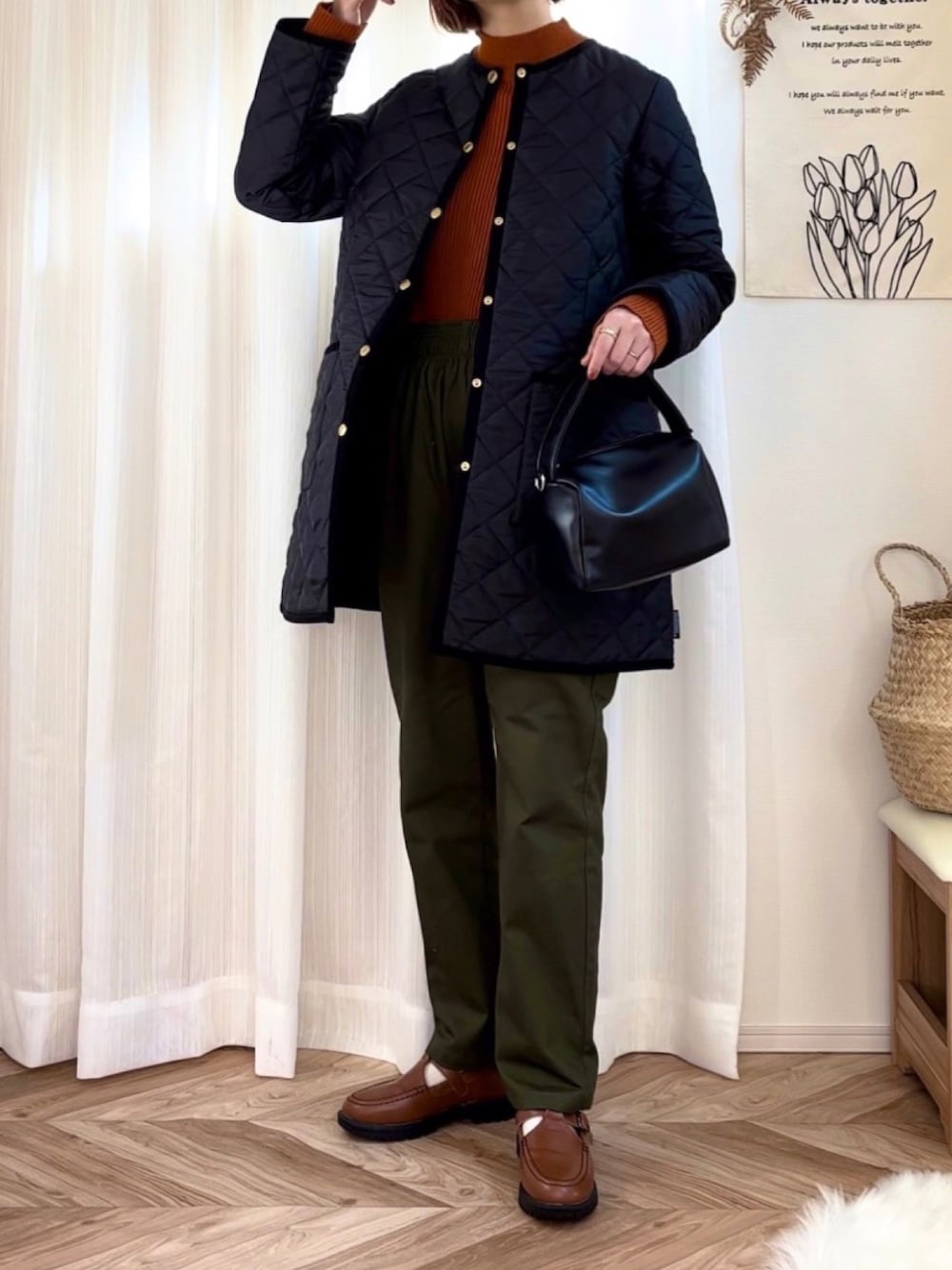 ブラック系のその他アウター、オレンジ系のニット/セーター、グリーン系のチノパンツを着用したレディースの冬コーディネートの1枚目の写真