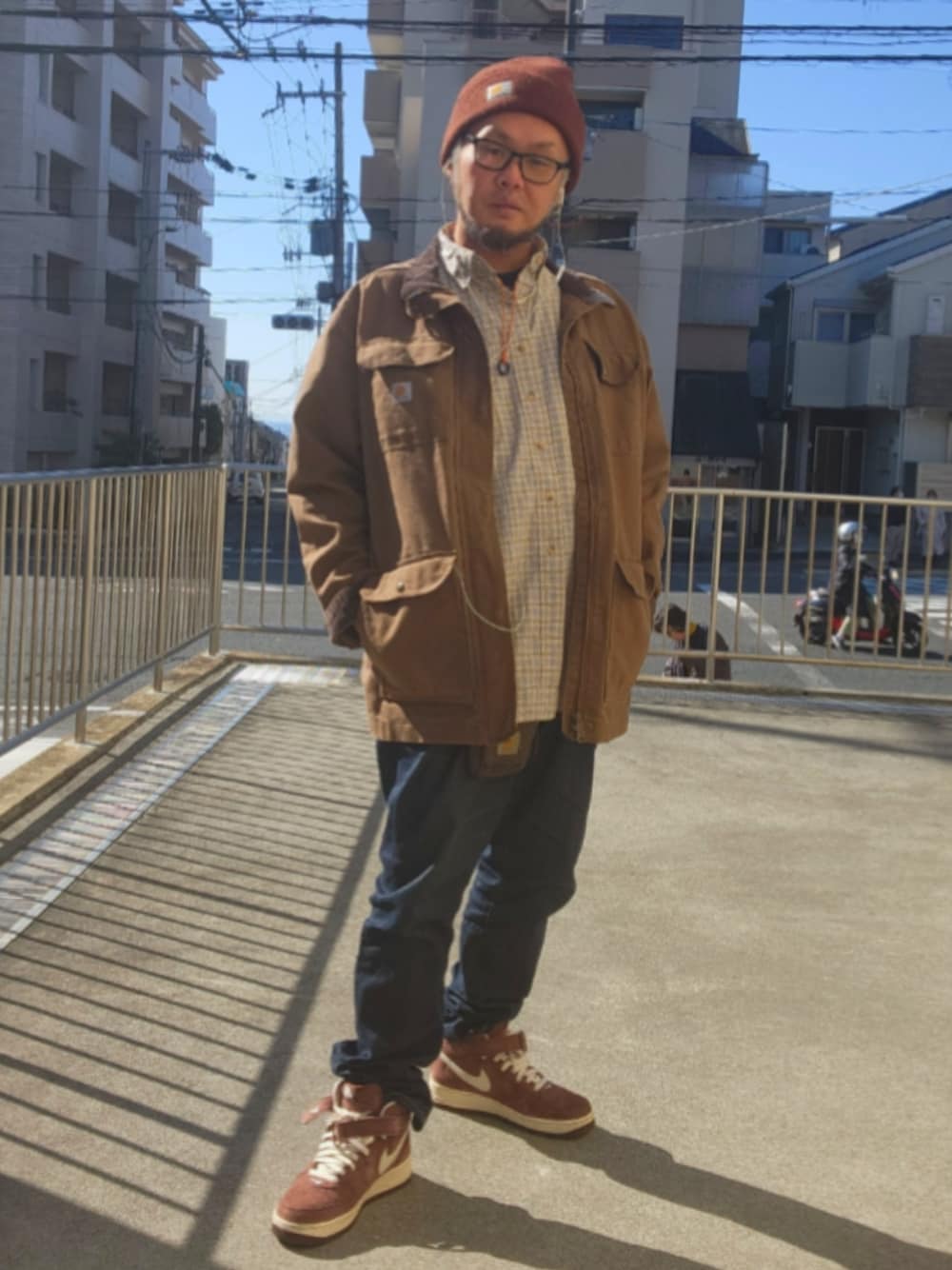 ブラウン系のスニーカー、ブルー系のデニムパンツ、ブラウン系のミリタリージャケットを着用したメンズの春コーディネートの1枚目の写真