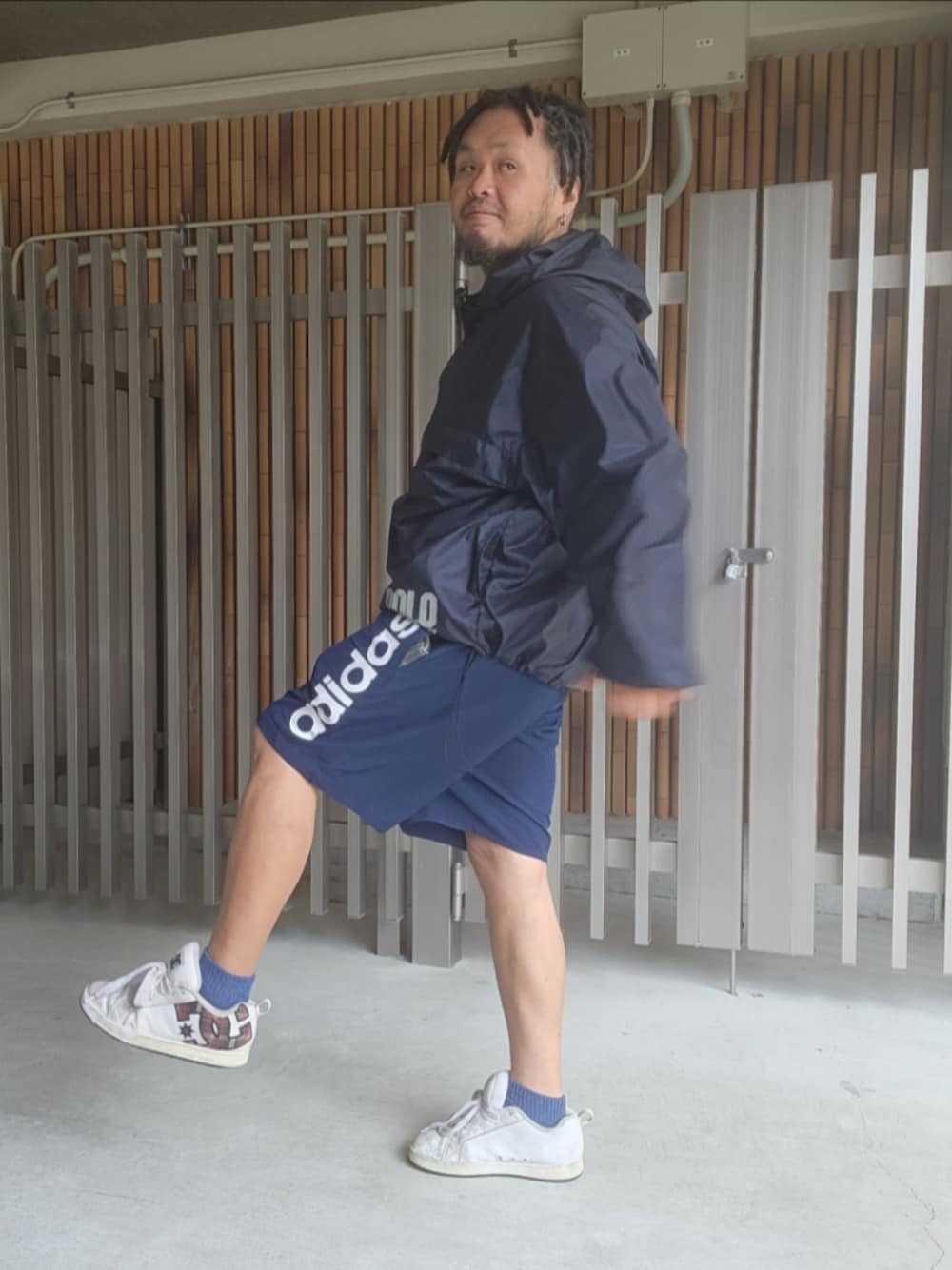 ブルー系のナイロンジャケット、ブルー系のその他パンツ、ホワイト系のスニーカーを着用したメンズの夏コーディネートの1枚目の写真