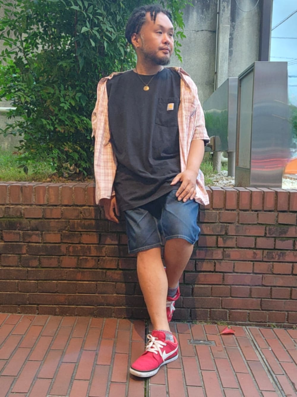 レッド系のスニーカー、ブルー系のデニムパンツ、ブラック系のTシャツ/カットソーを着用したメンズの春コーディネートの1枚目の写真