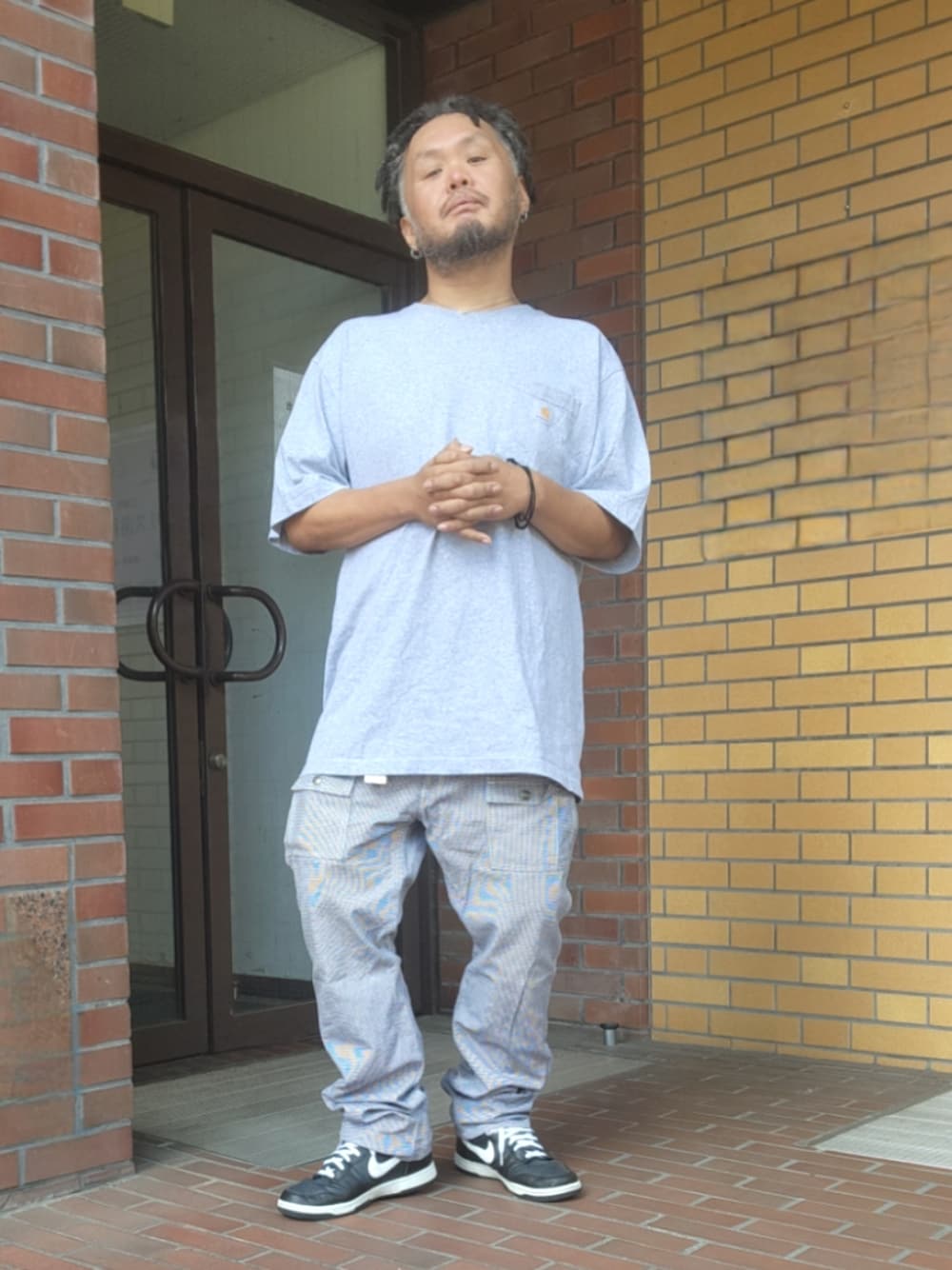 ブラック系のスニーカー、その他のカーゴパンツ、グレー系のTシャツ/カットソーを着用したメンズの春コーディネートの1枚目の写真
