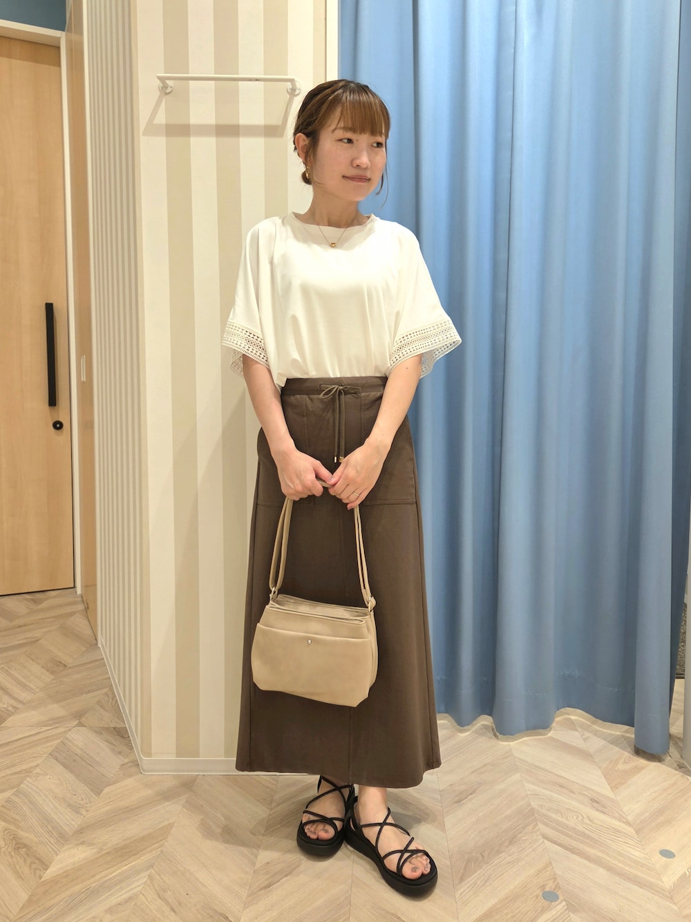 ホワイト系のTシャツ/カットソー、ブラウン系のスカートを着用したレディースの夏コーディネートの1枚目の写真