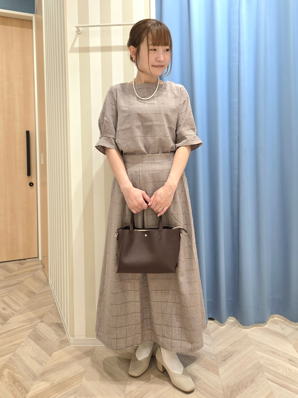 ベージュ系のシャツ/ブラウス、ベージュ系のスカート、ベージュ系のパンプスを着用したレディースの秋コーディネートの1枚目の写真