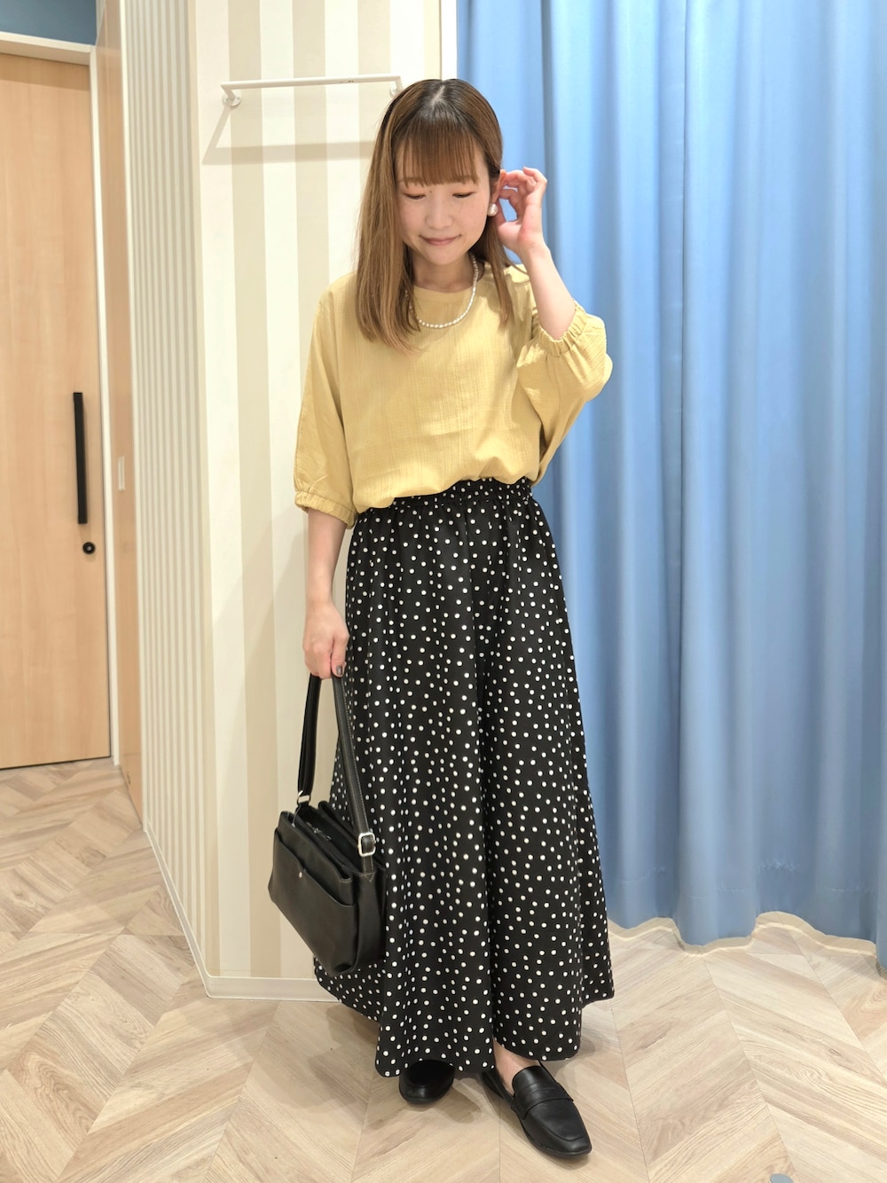 イエロー系のシャツ/ブラウス、ブラック系のスカート、ブラック系のパンプスを着用したレディースの秋コーディネートの1枚目の写真