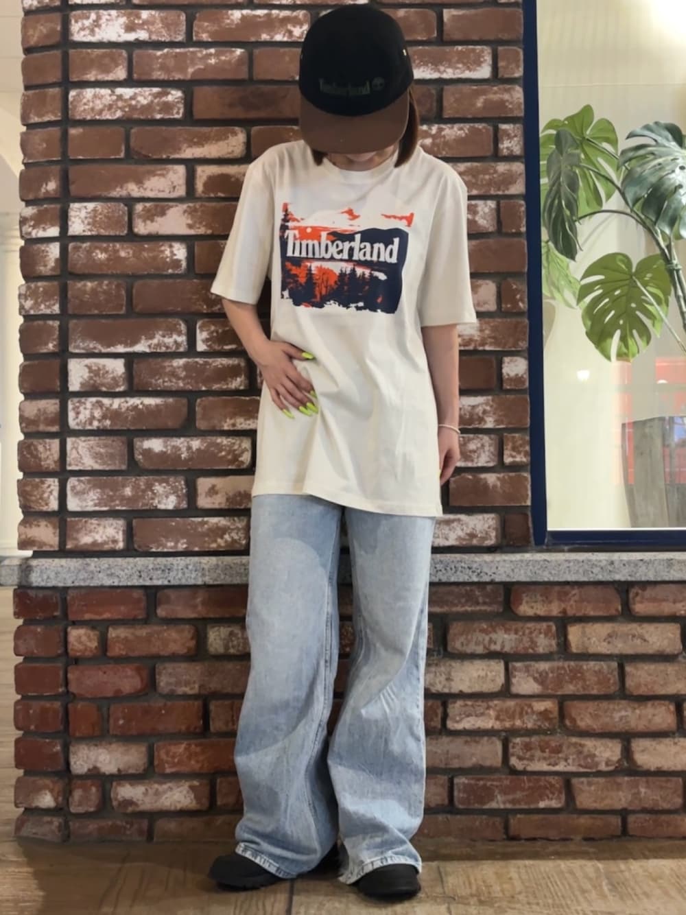 ホワイト系のTシャツ/カットソー、ブラック系のスニーカー、ブラック系のキャップを着用したレディースの夏コーディネートの1枚目の写真