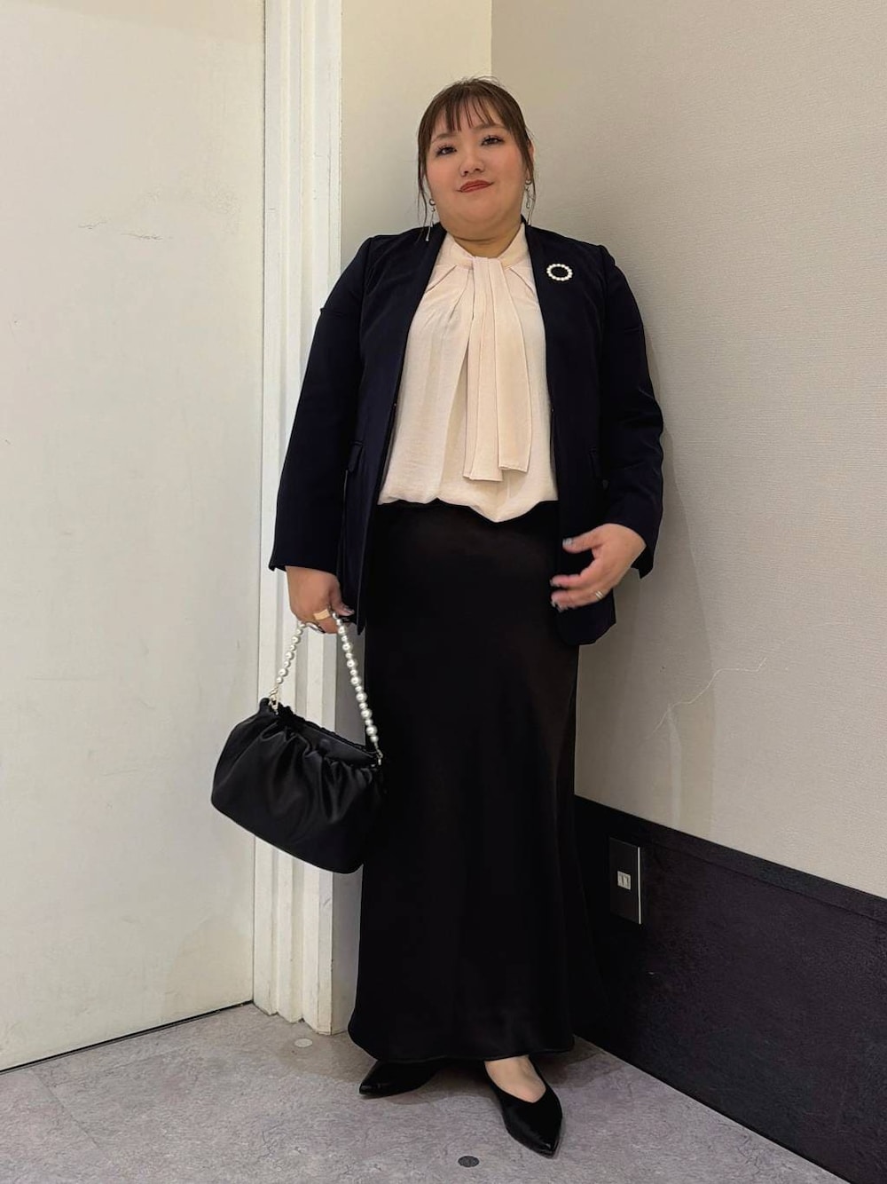 ブラック系のスカート、ブルー系のテーラードジャケット、ピンク系のシャツ/ブラウスを着用したレディースの冬コーディネートの1枚目の写真