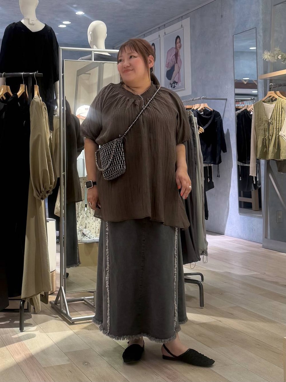 シルバー系のショルダーバッグ、ブラック系のパンプス、ブラウン系のシャツ/ブラウスを着用したレディースの春コーディネートの1枚目の写真