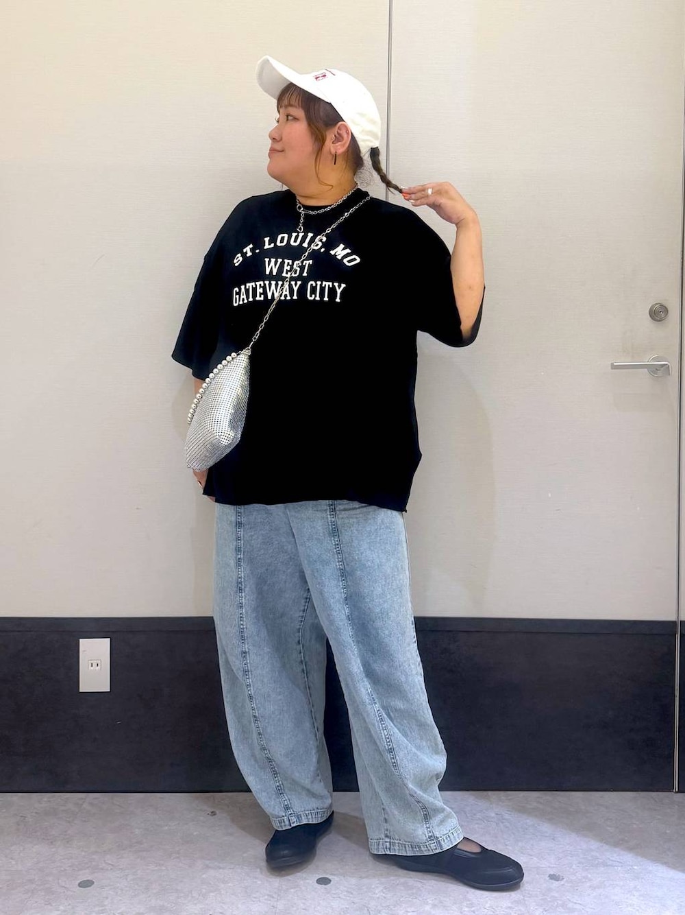 ブラック系のパンプス、シルバー系のショルダーバッグ、ブルー系のデニムパンツを着用したレディースの春コーディネートの1枚目の写真