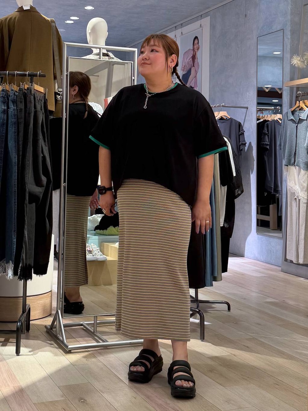 ブラック系のTシャツ/カットソー、グリーン系のワンピース、シルバー系のネックレスを着用したレディースの春コーディネートの1枚目の写真