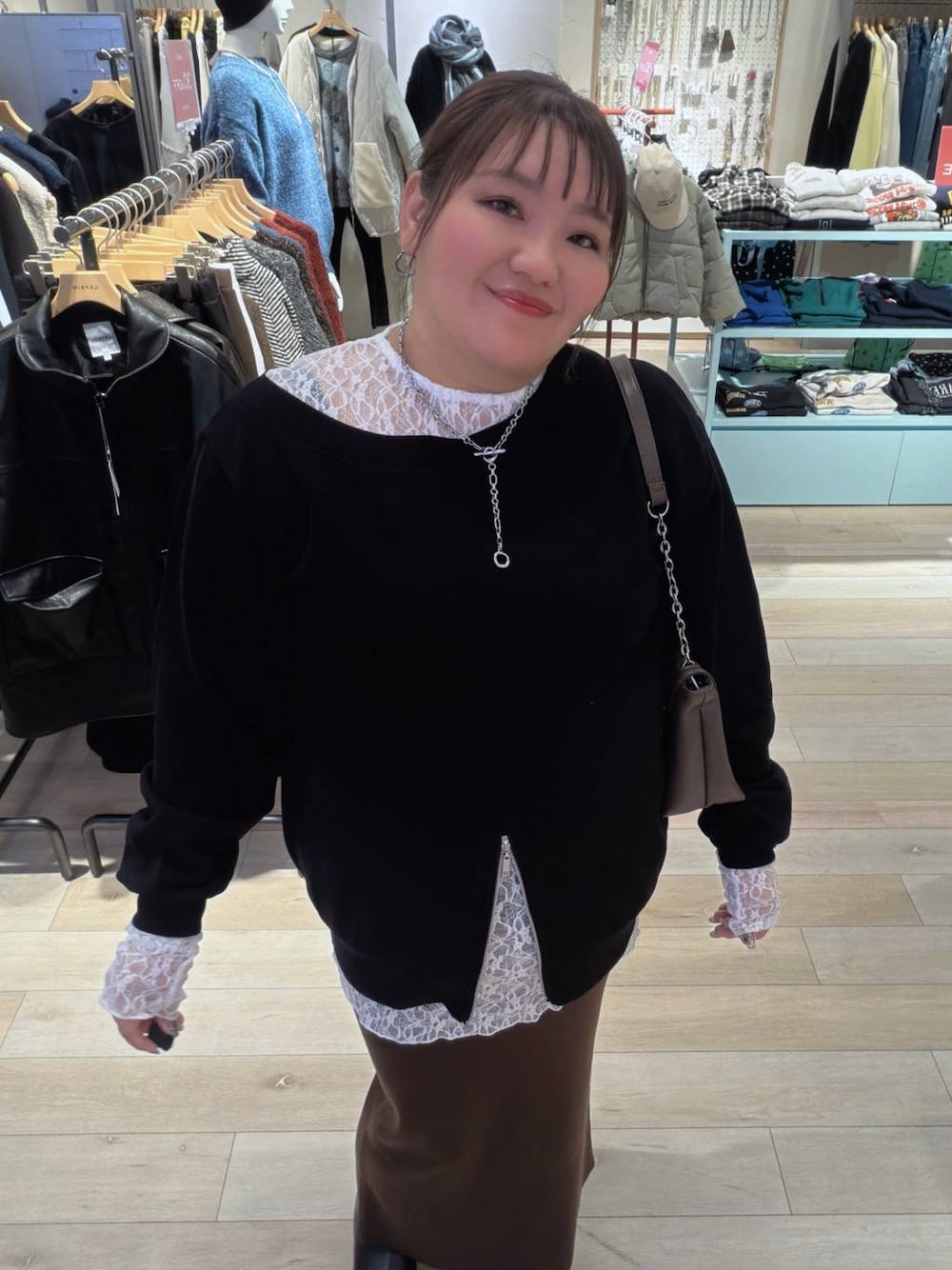 ブラウン系のスカート、ブラウン系のショルダーバッグ、ブラック系のTシャツ/カットソーを着用したレディースの冬コーディネートの1枚目の写真