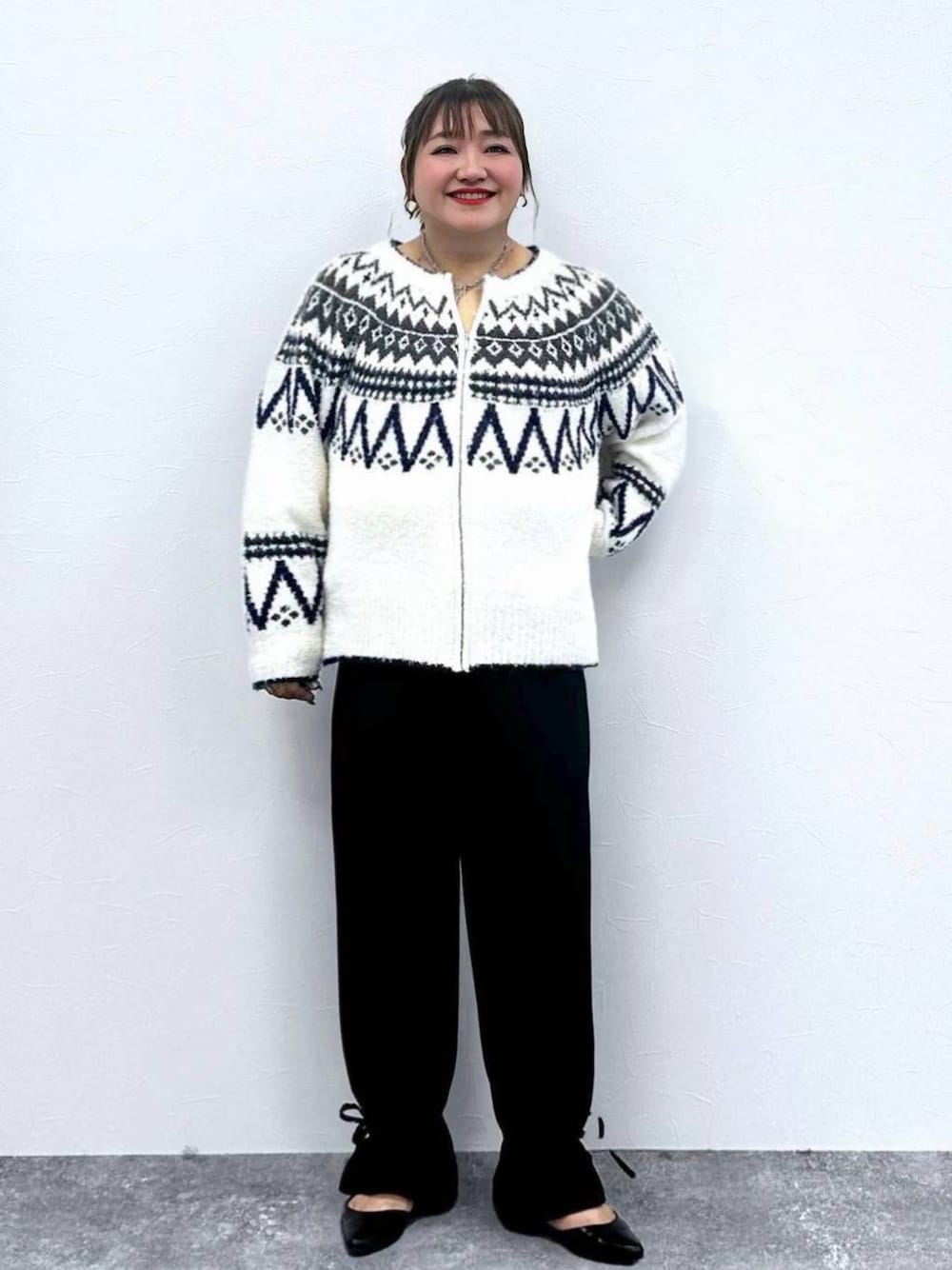 ブラック系のパンプス、ホワイト系のカーディガン/ボレロ、ブラック系のその他パンツを着用したレディースの秋コーディネートの1枚目の写真