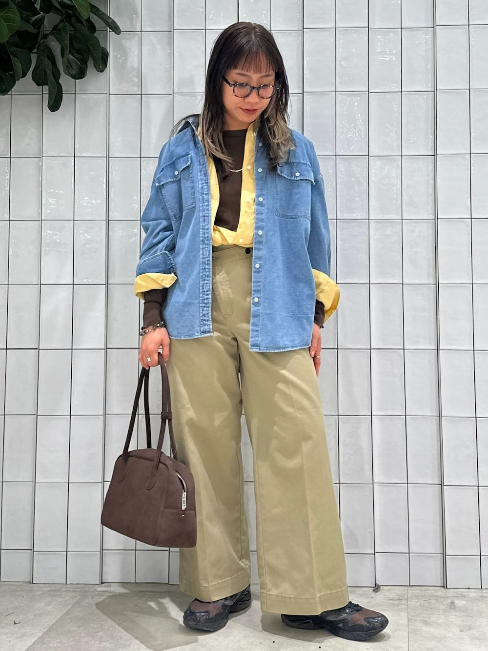 ベージュ系のチノパンツ、ブルー系のシャツ/ブラウス、イエロー系のシャツ/ブラウスを着用したレディースの春コーディネートの1枚目の写真
