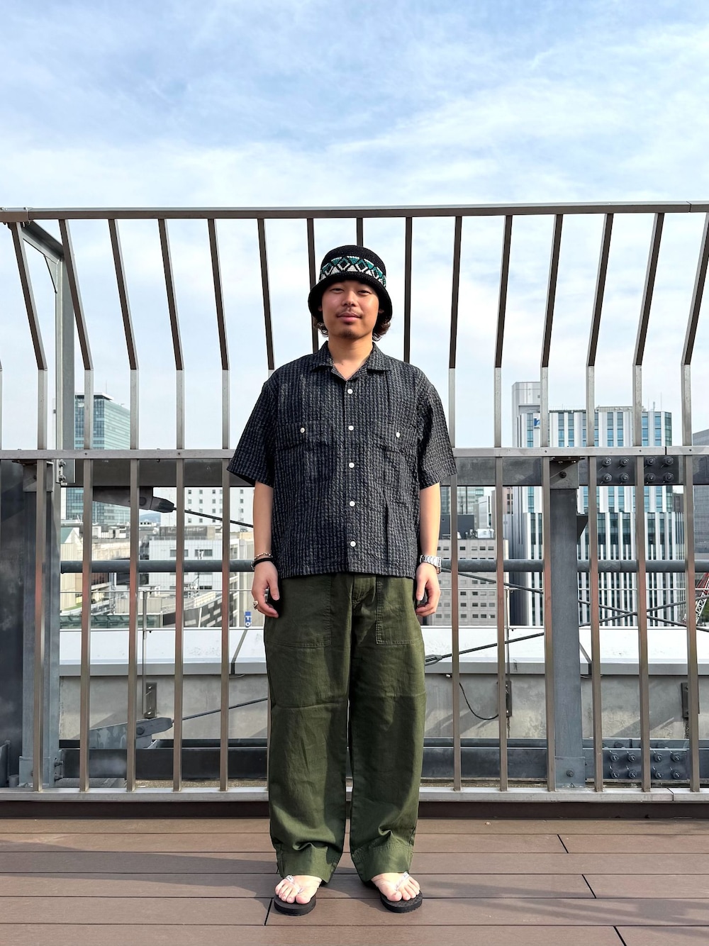 グリーン系のカーゴパンツ、ブルー系のシャツ/ブラウス、ホワイト系のサンダルを着用したメンズの春コーディネートの1枚目の写真