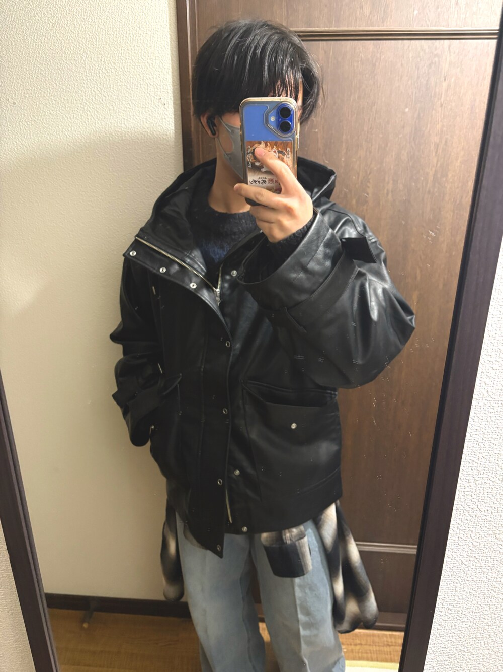 ブラック系のニット/セーター、ブラック系のマウンテンパーカー、ブルー系のデニムパンツを着用したメンズの冬コーディネートの1枚目の写真