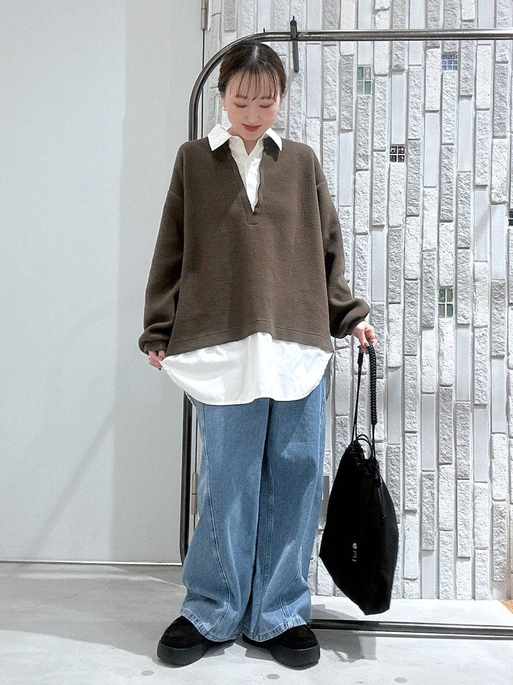 ブラック系のトートバッグ、ブルー系のデニムパンツ、ブラック系のブーツを着用したレディースの冬コーディネートの1枚目の写真