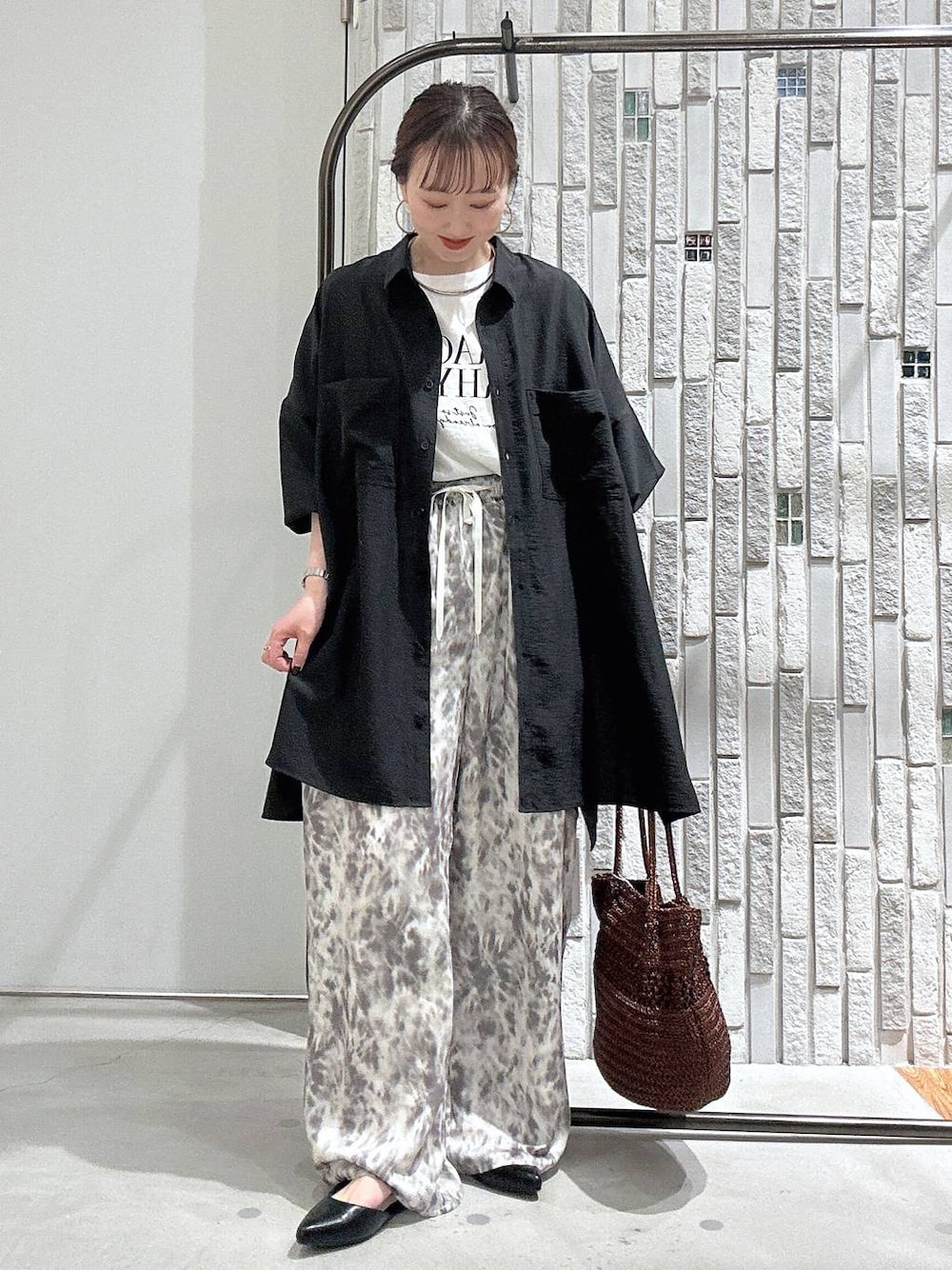 グレー系のシャツ/ブラウス、ブラウン系のショルダーバッグ、ブラック系のパンプスを着用したレディースの春コーディネートの1枚目の写真