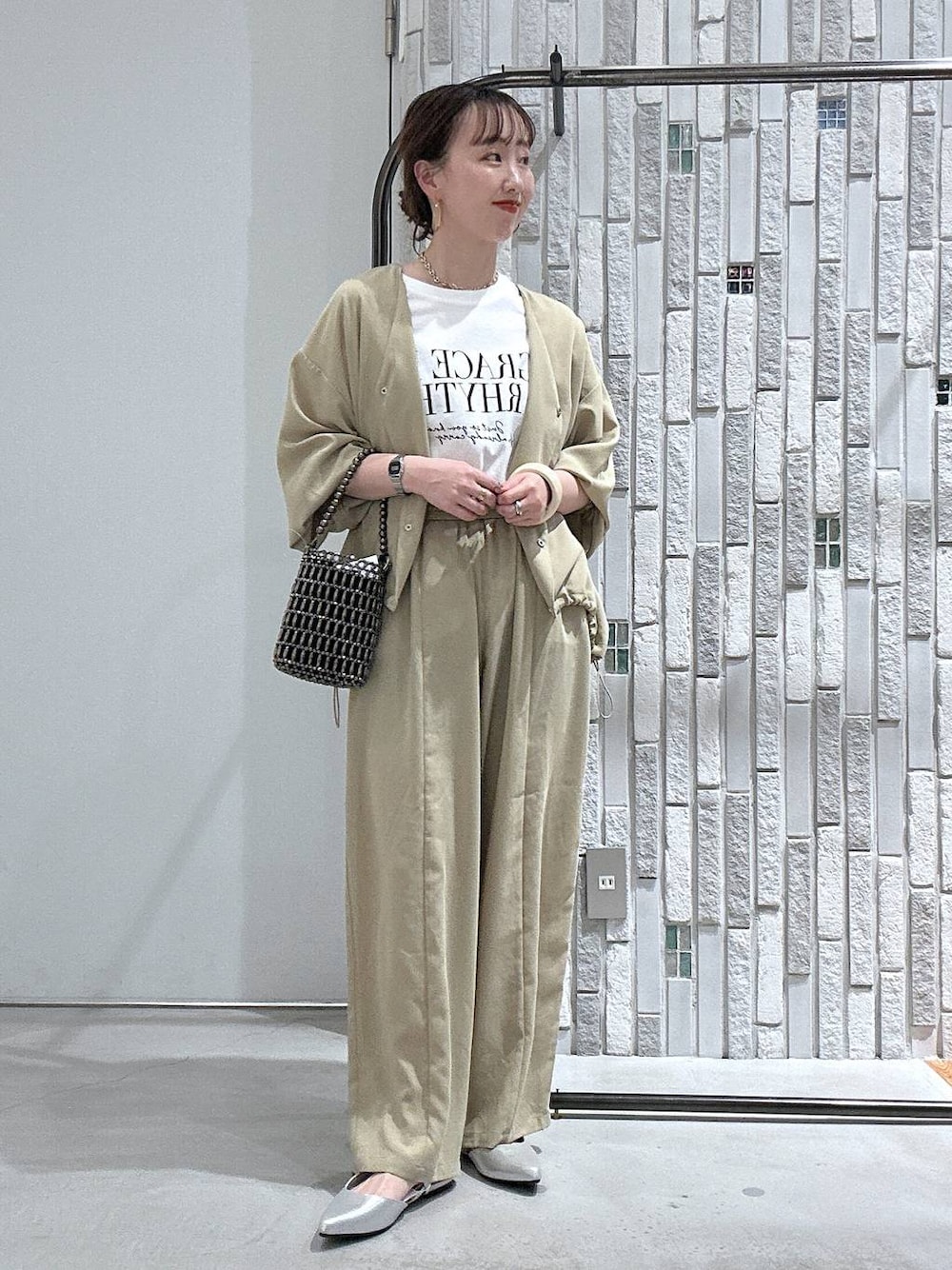 ベージュ系のその他パンツ、ベージュ系のシャツ/ブラウス、シルバー系のショルダーバッグを着用したレディースの春コーディネートの1枚目の写真