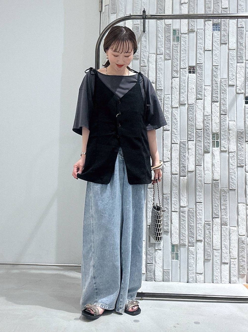 グレー系のTシャツ/カットソー、ブルー系のデニムパンツ、シルバー系のショルダーバッグを着用したレディースの夏コーディネートの1枚目の写真