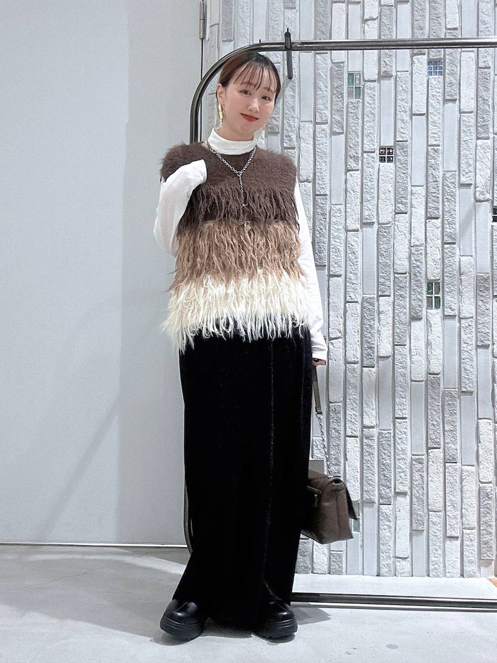 ホワイト系のTシャツ/カットソー、ブラック系のブーツ、ブラック系のスカートを着用したレディースの冬コーディネートの1枚目の写真