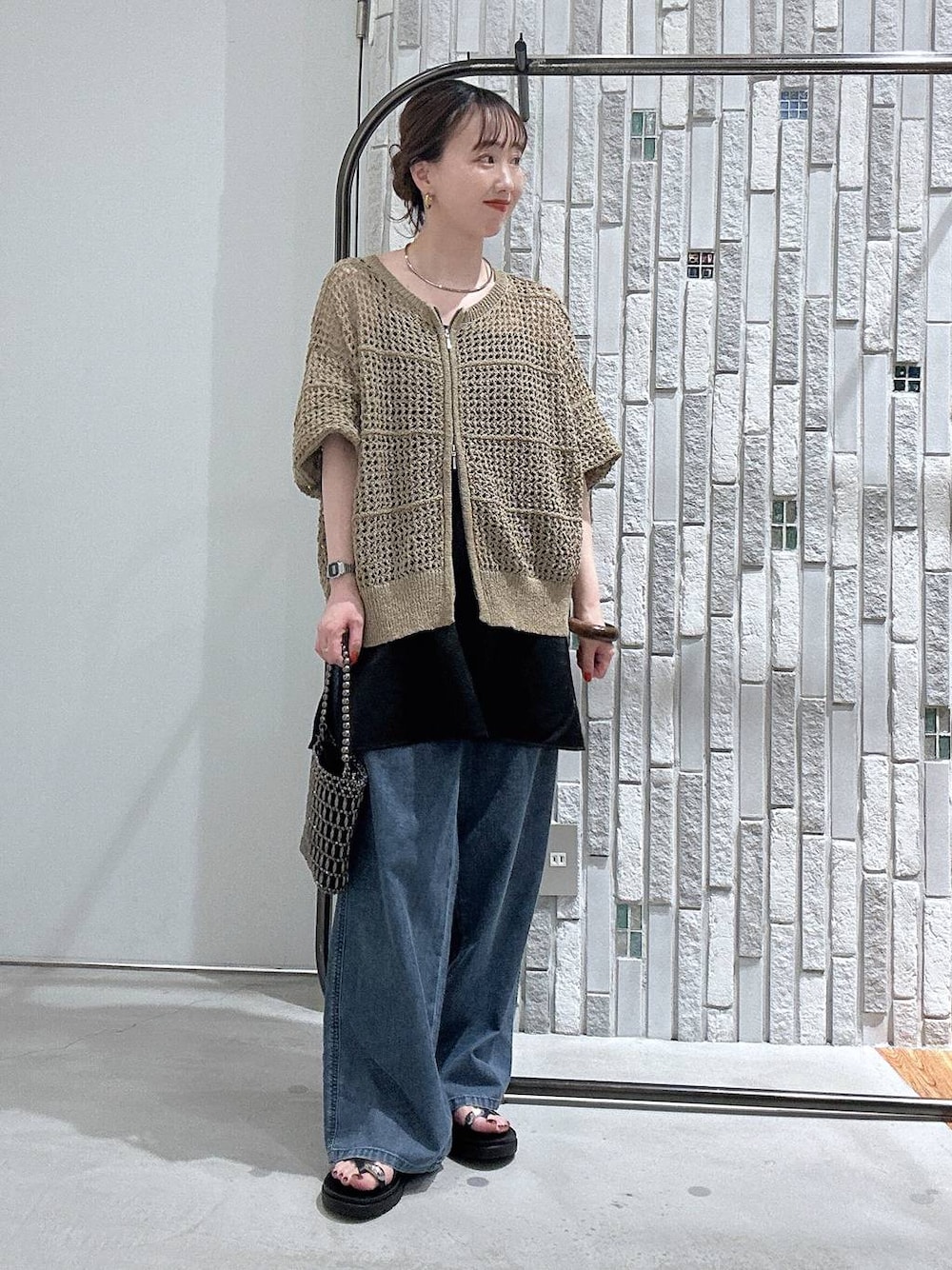 ブルー系のデニムパンツ、その他のショルダーバッグ、ブラック系のキャミソールを着用したレディースの春コーディネートの1枚目の写真