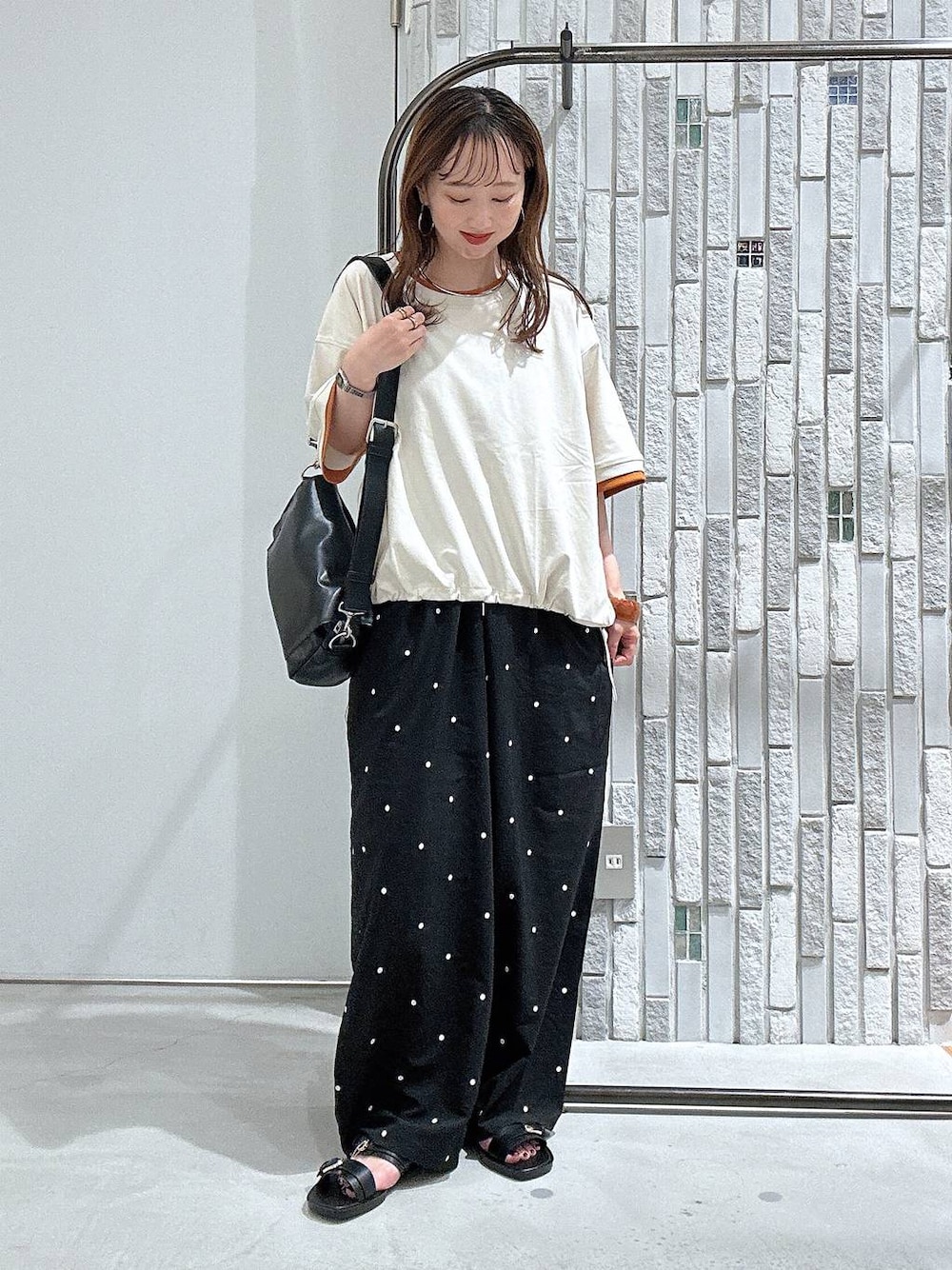 ベージュ系のTシャツ/カットソー、ブラック系のショルダーバッグ、ブラック系のその他パンツを着用したレディースの夏コーディネートの1枚目の写真