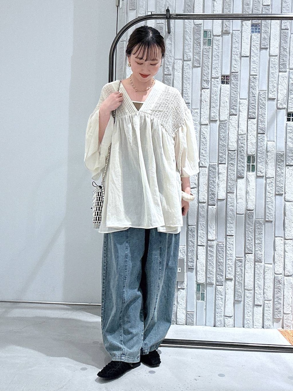 ベージュ系のシャツ/ブラウス、シルバー系のショルダーバッグ、ブラック系のパンプスを着用したレディースの春コーディネートの1枚目の写真