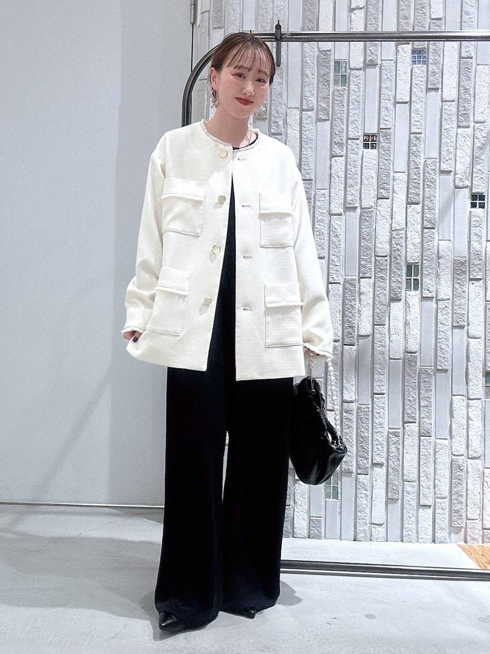 ホワイト系のノーカラージャケット、ブルー系のサロペット/オーバーオール、ブラック系のショルダーバッグを着用したレディースの冬コーディネートの1枚目の写真