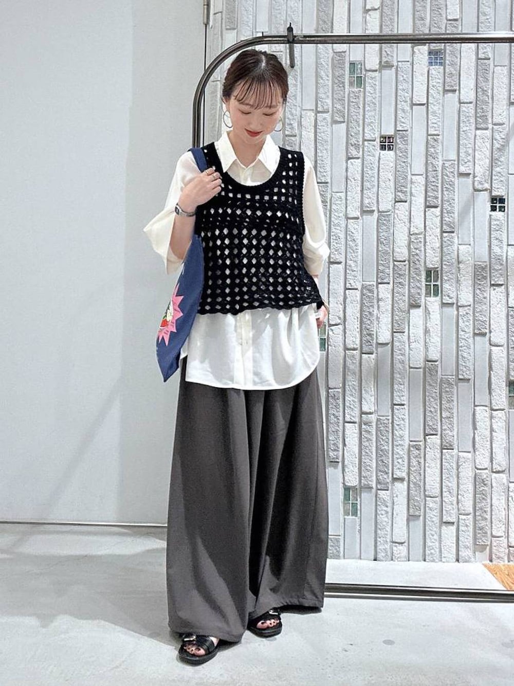 ブラック系のベスト、ブラック系のサンダル、ホワイト系のシャツ/ブラウスを着用したレディースの夏コーディネートの1枚目の写真