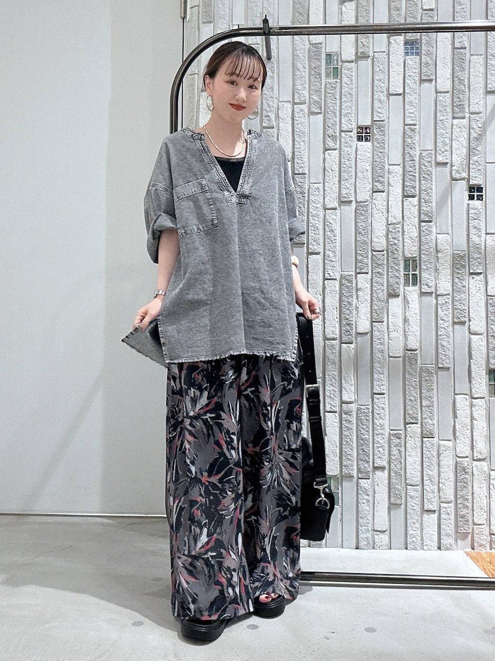 グレー系のその他パンツ、ブラック系のショルダーバッグ、ブラック系のサンダルを着用したレディースの春コーディネートの1枚目の写真
