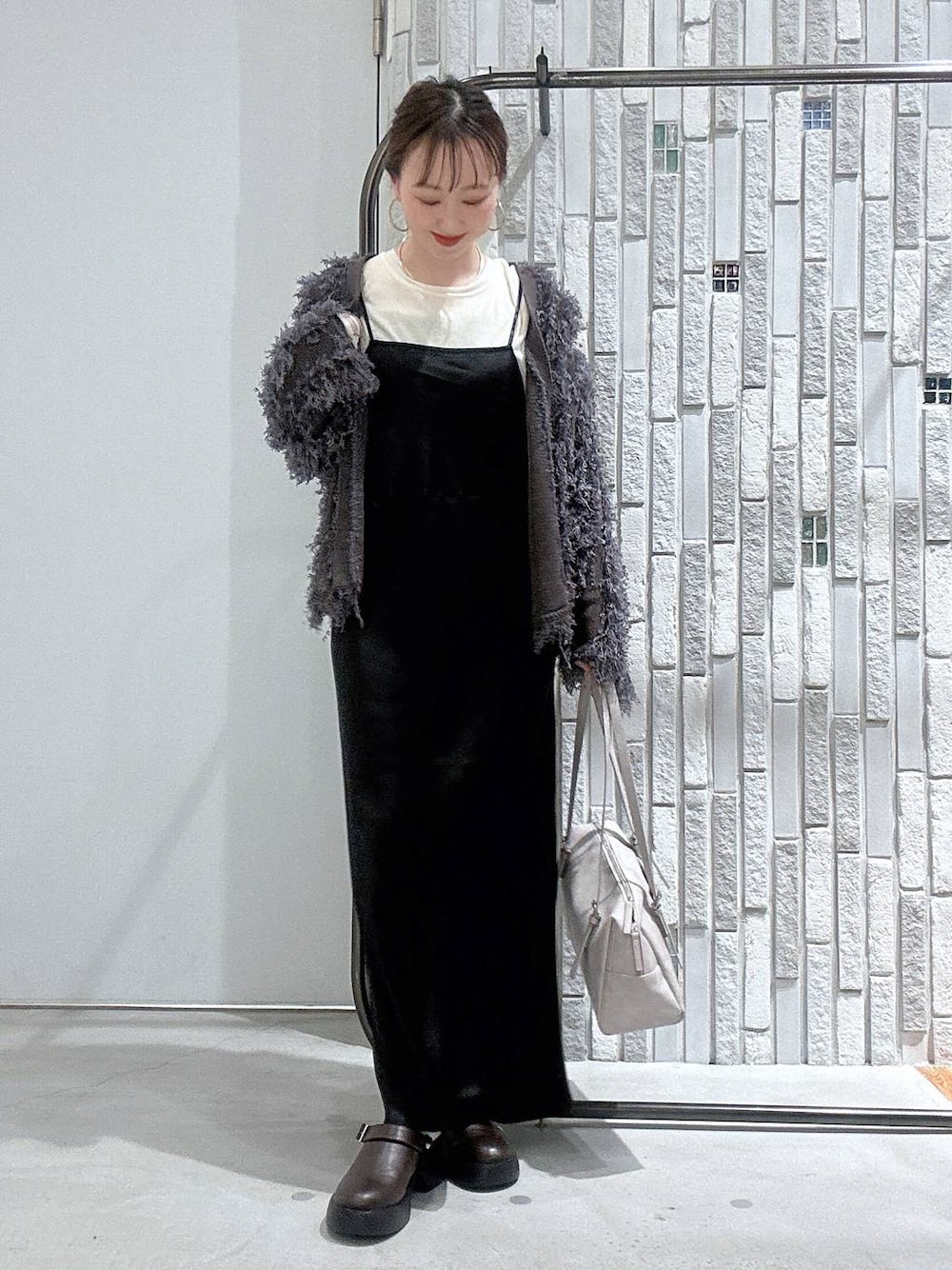 ブラウン系のサンダル、グレー系のボストンバッグ、ホワイト系のTシャツ/カットソーを着用したレディースの冬コーディネートの1枚目の写真