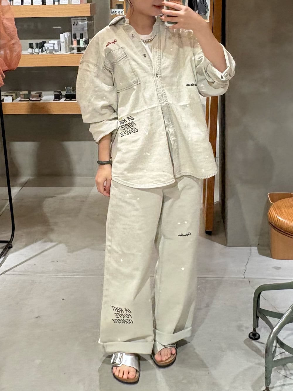 グレー系のシャツ/ブラウス、グレー系のデニムパンツ、シルバー系のサンダルを着用したレディースの夏コーディネートの1枚目の写真