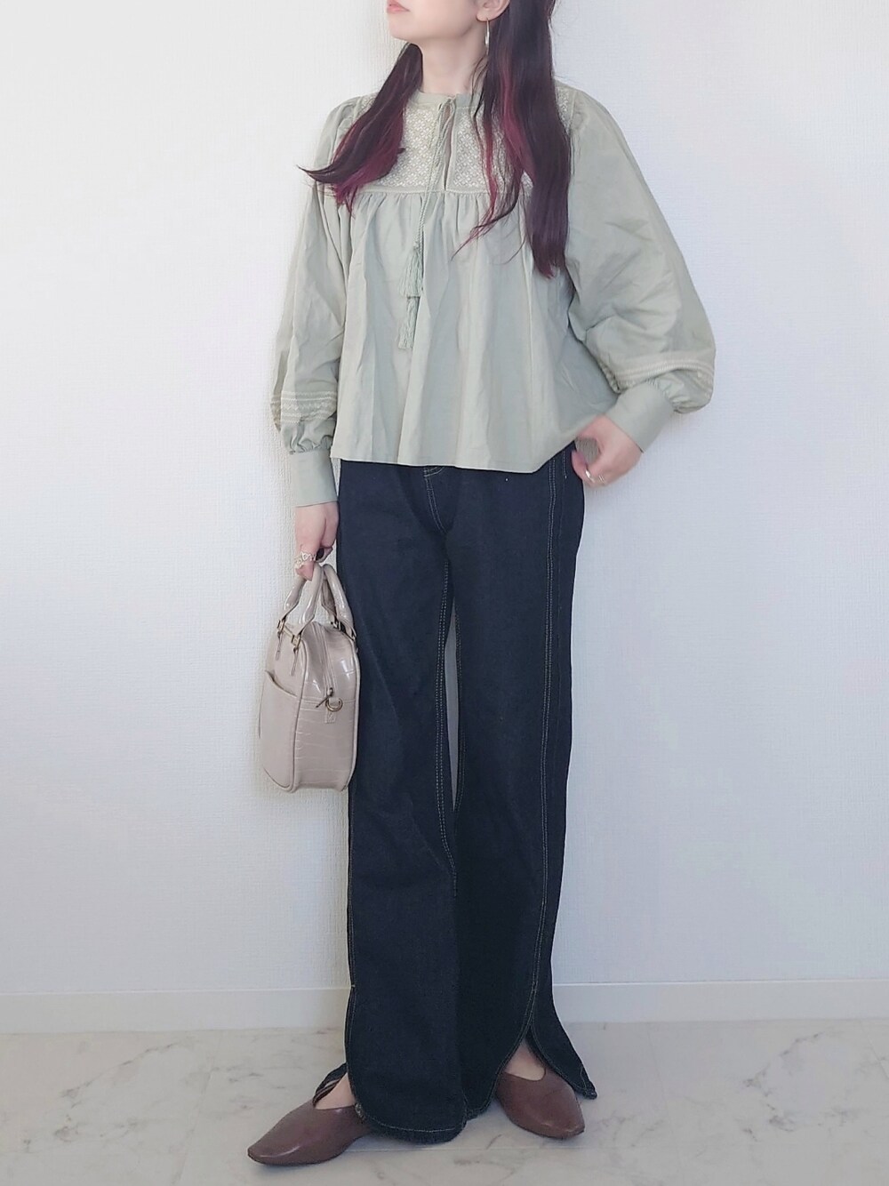 グリーン系のシャツ/ブラウス、ブルー系のデニムパンツ、ブラック系のブーツを着用したレディースの春コーディネートの3枚目の写真