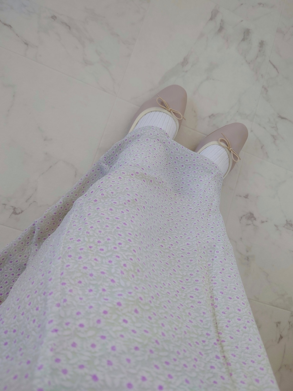 グリーン系のカーディガン/ボレロ、ホワイト系のシャツ/ブラウス、グリーン系のスカートを着用したレディースの春コーディネートの4枚目の写真