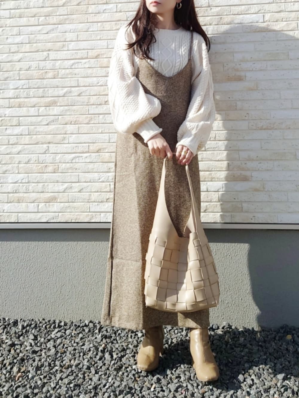 ブラウン系のワンピース、ホワイト系のニット/セーター、ベージュ系のショルダーバッグを着用したレディースの冬コーディネートの1枚目の写真