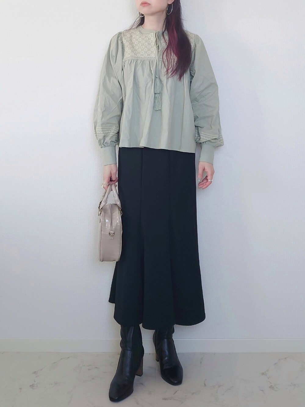 グリーン系のシャツ/ブラウス、ブルー系のデニムパンツ、ブラック系のブーツを着用したレディースの春コーディネートの2枚目の写真