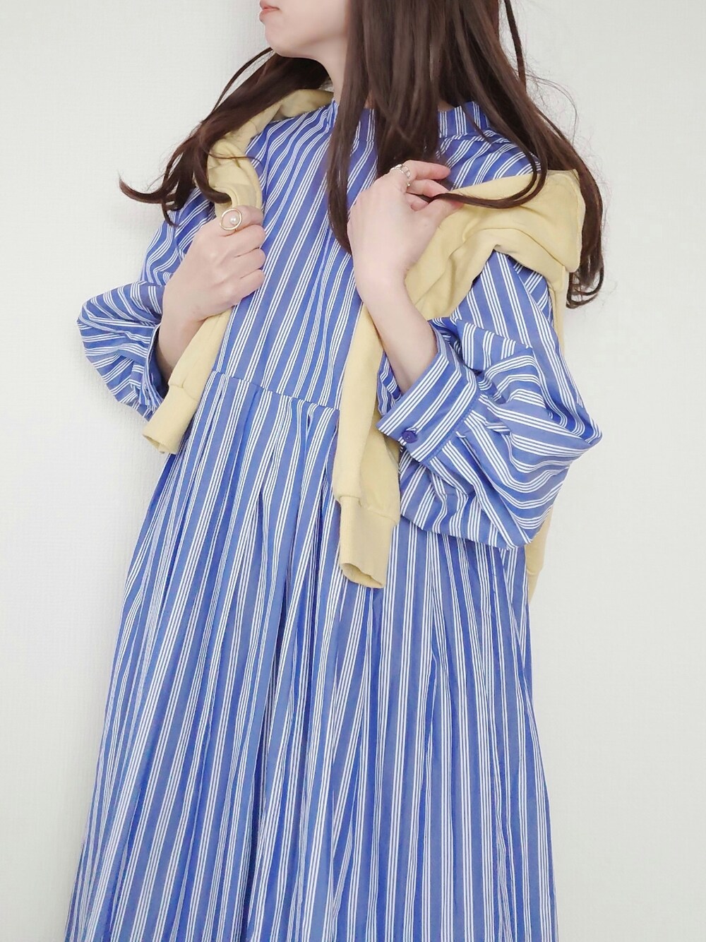 ブルー系のドレス、ベージュ系のボストンバッグ、ブルー系のデニムパンツを着用したレディースの冬コーディネートの2枚目の写真