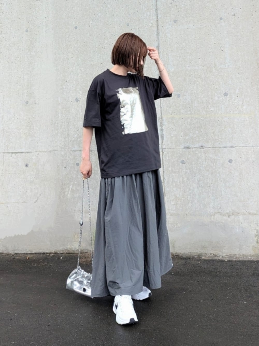 ブラック系のTシャツ/カットソー、グレー系のスカート、シルバー系のショルダーバッグを着用したレディースの夏コーディネートの1枚目の写真