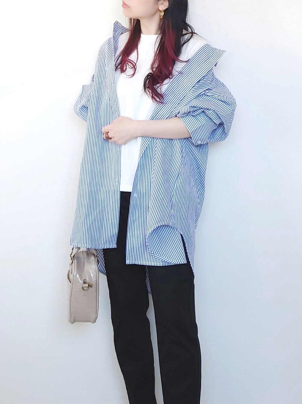 ブルー系のシャツ/ブラウス、ブラック系のデニムパンツ、グレー系のショルダーバッグを着用したレディースの春コーディネートの2枚目の写真