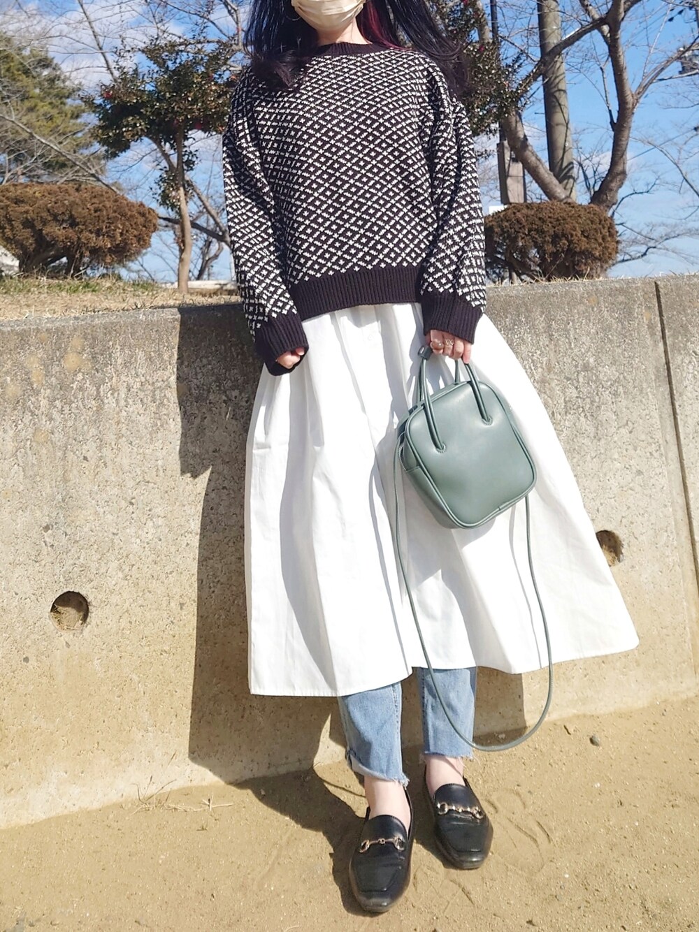ブラック系のその他トップス、ホワイト系のワンピース/ドレス、グリーン系のショルダーバッグを着用したレディースの冬コーディネートの3枚目の写真
