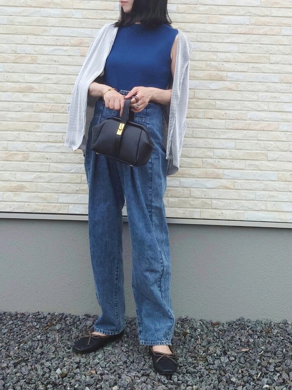 ブルー系のニット/セーター、ホワイト系のシャツ/ブラウス、ブラック系のショルダーバッグを着用したレディースの夏コーディネートの1枚目の写真