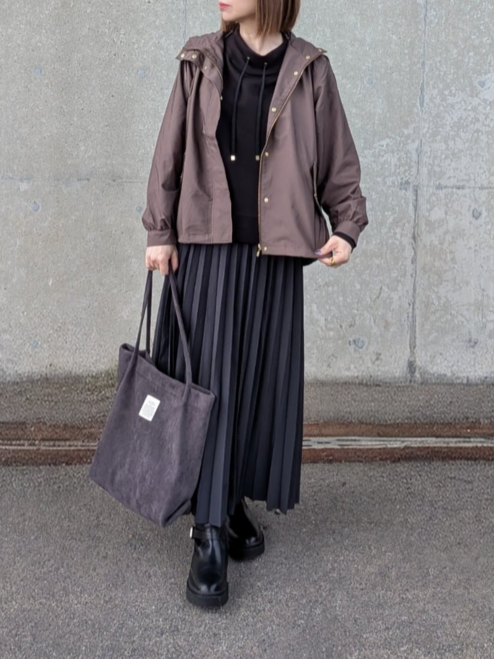 ブラウン系のブルゾン、ブラック系のスウェット、グレー系のスカートを着用したレディースの秋コーディネートの1枚目の写真