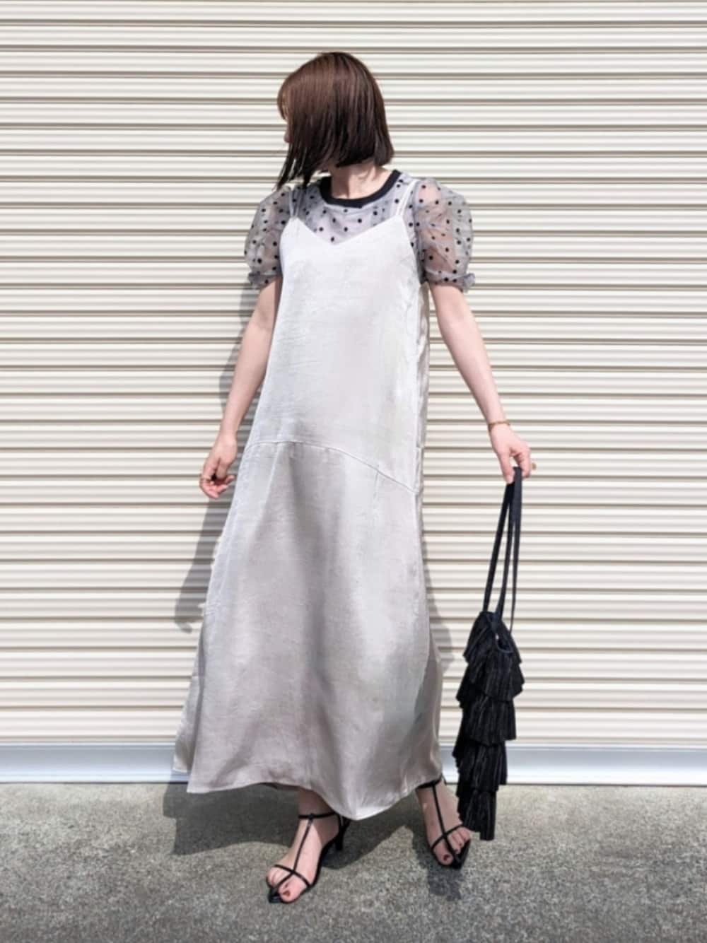 ベージュ系のワンピース、グレー系のチューブトップ、ブラック系のサンダルを着用したレディースの夏コーディネートの1枚目の写真