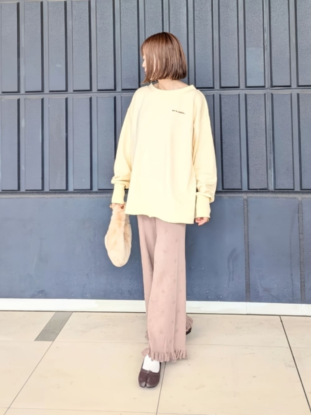 ホワイト系のスウェット、ブラウン系のその他パンツ、ベージュ系のハンドバッグを着用したレディースの秋コーディネートの1枚目の写真