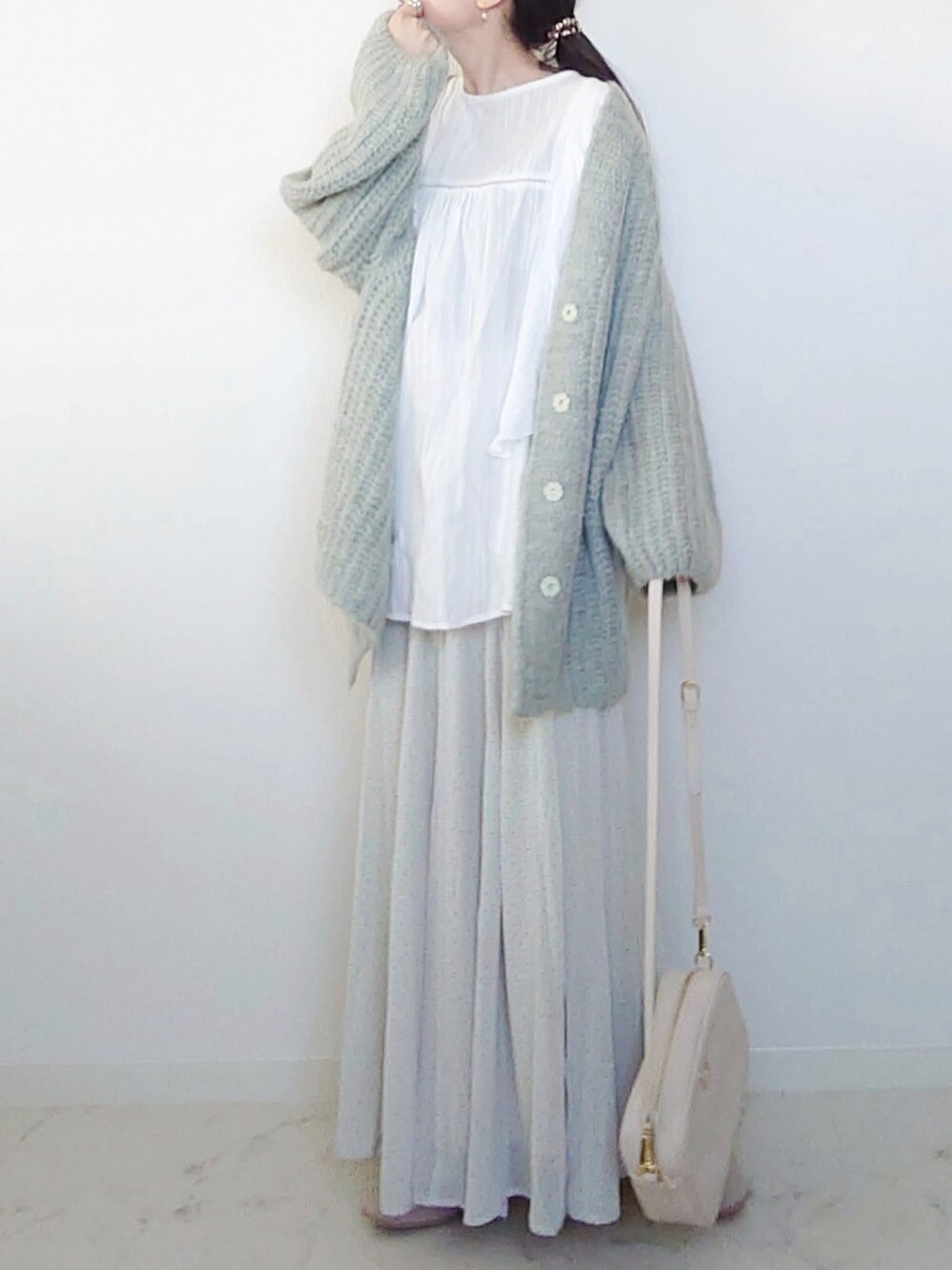 グリーン系のカーディガン/ボレロ、ホワイト系のシャツ/ブラウス、グリーン系のスカートを着用したレディースの春コーディネートの2枚目の写真