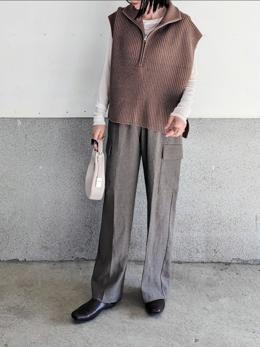 ブラウン系のベスト、ホワイト系のTシャツ/カットソー、ブラウン系のカーゴパンツを着用したレディースの秋コーディネートの1枚目の写真