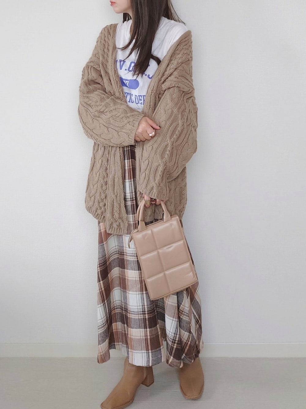 ベージュ系のカーディガン/ボレロ、ホワイト系のTシャツ/カットソー、ベージュ系のブーツを着用したレディースの秋コーディネートの1枚目の写真