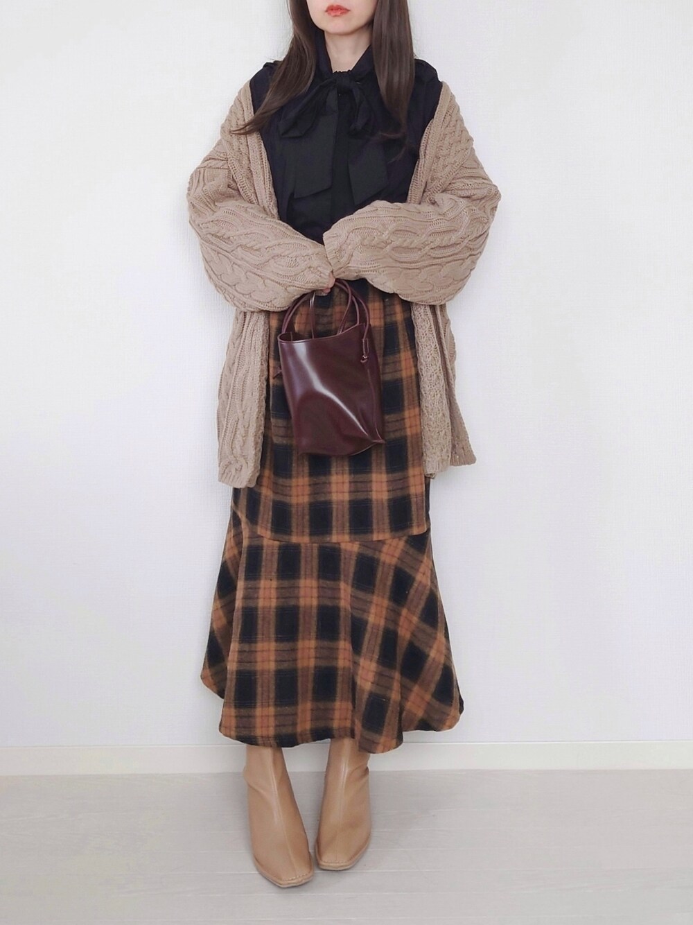 ベージュ系のカーディガン/ボレロ、ブラウン系のショルダーバッグ、ベージュ系のブーツを着用したレディースの秋コーディネートの1枚目の写真
